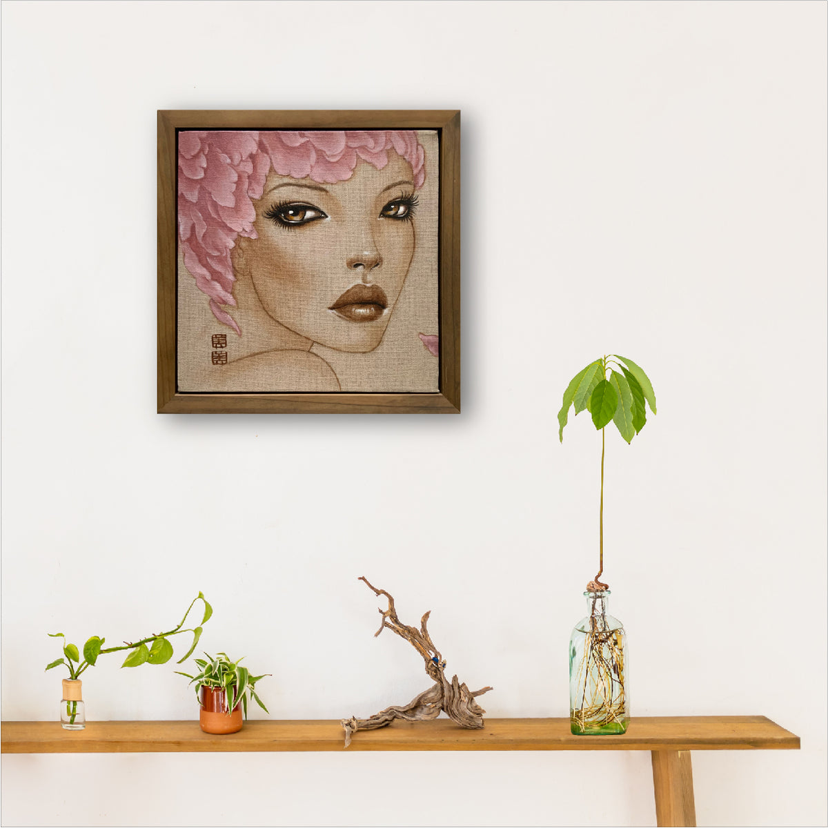 framed painting of a woman's face - she has large eyes and lips and is wearing a feather hat