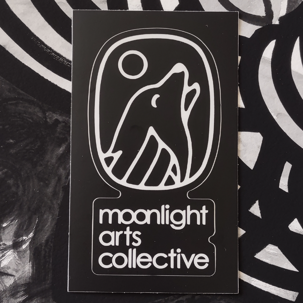moonlight arts collective sticker - white logo on black background