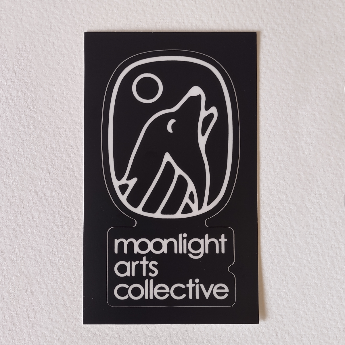 moonlight arts collective sticker - white logo on black background